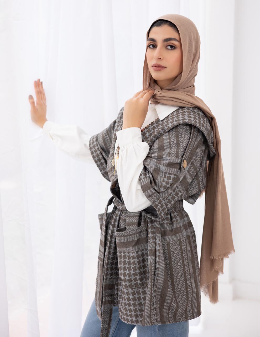 Palestinian heritage print coat in cafe