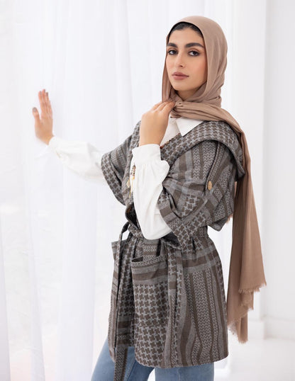 Palestinian heritage print coat in cafe