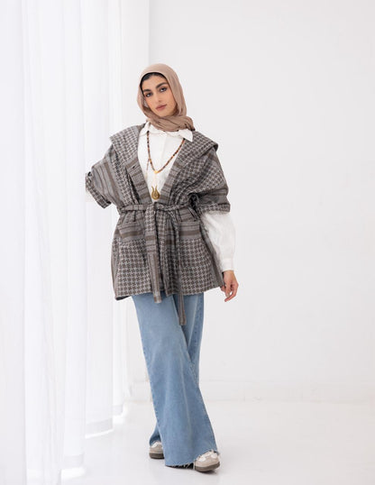 Palestinian heritage print coat in cafe